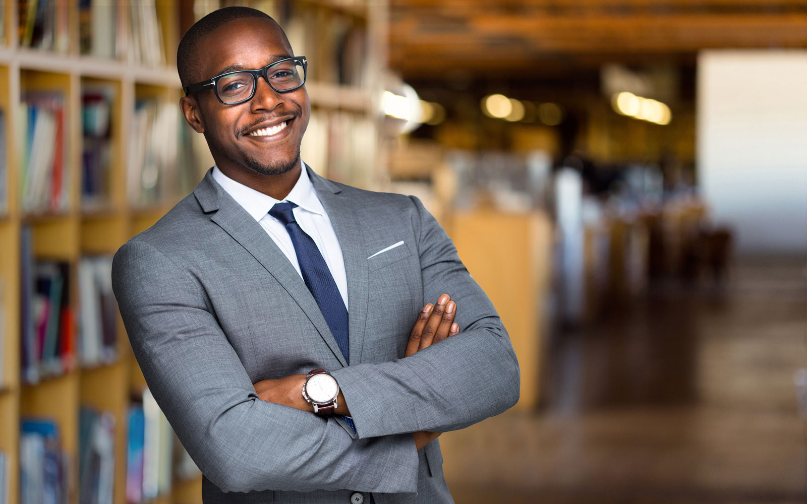 Confident smiling educator standing in library