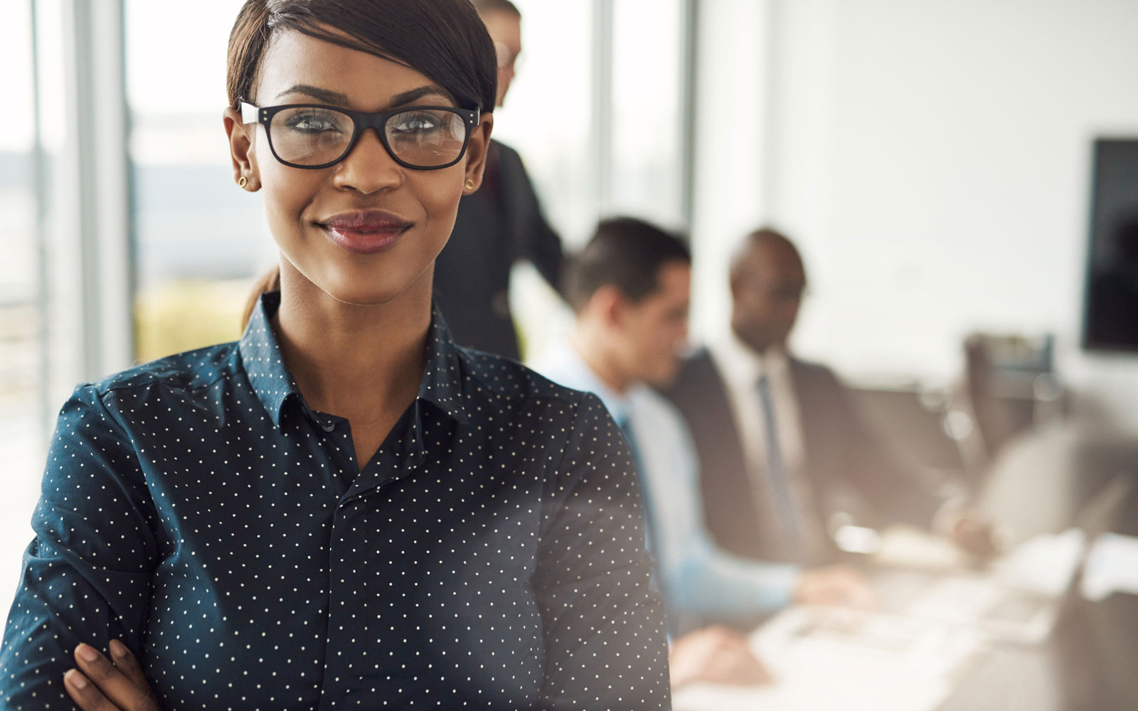 Confident woman standing in front of business meeting