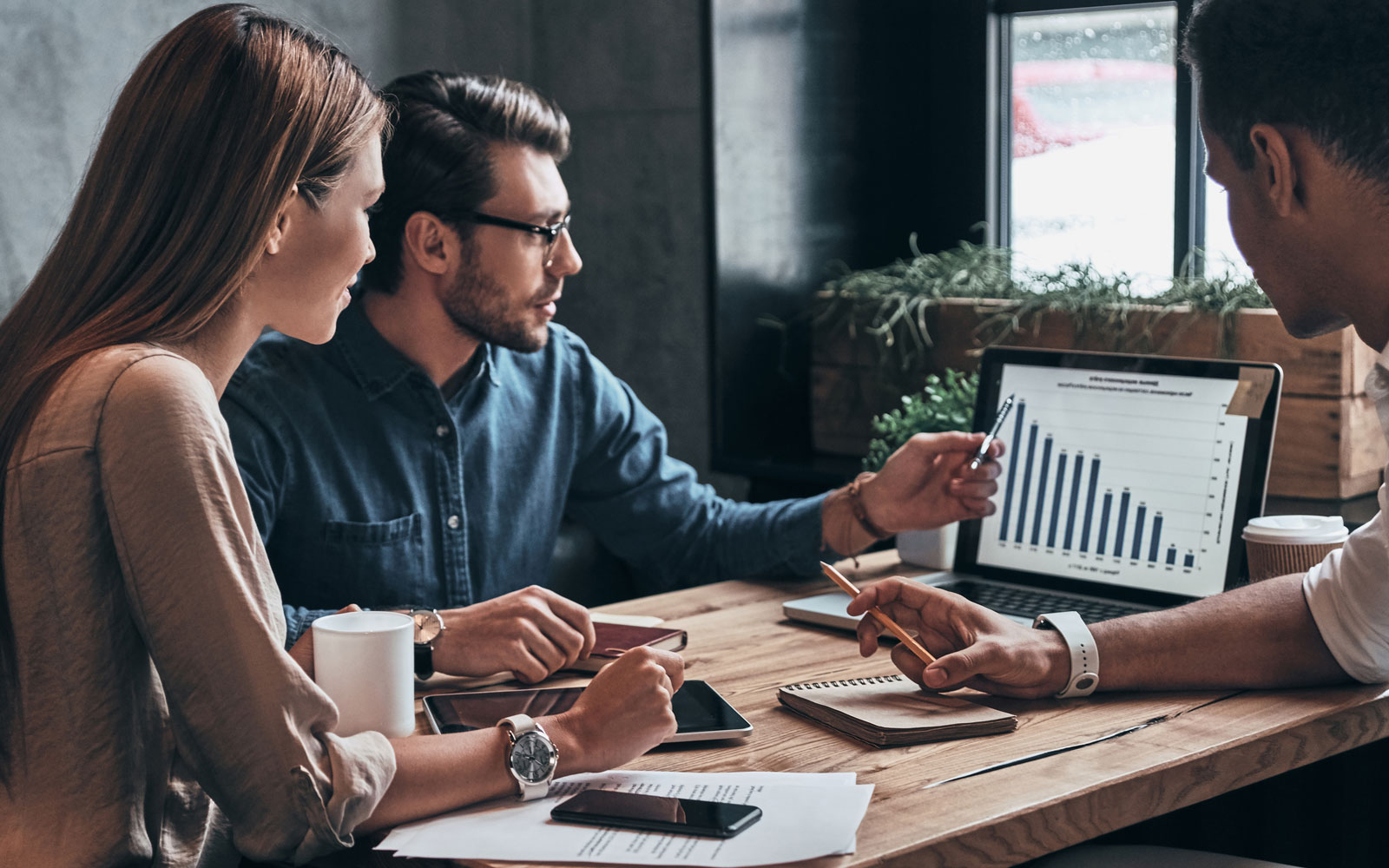 group of people looking at analytics on laptop
