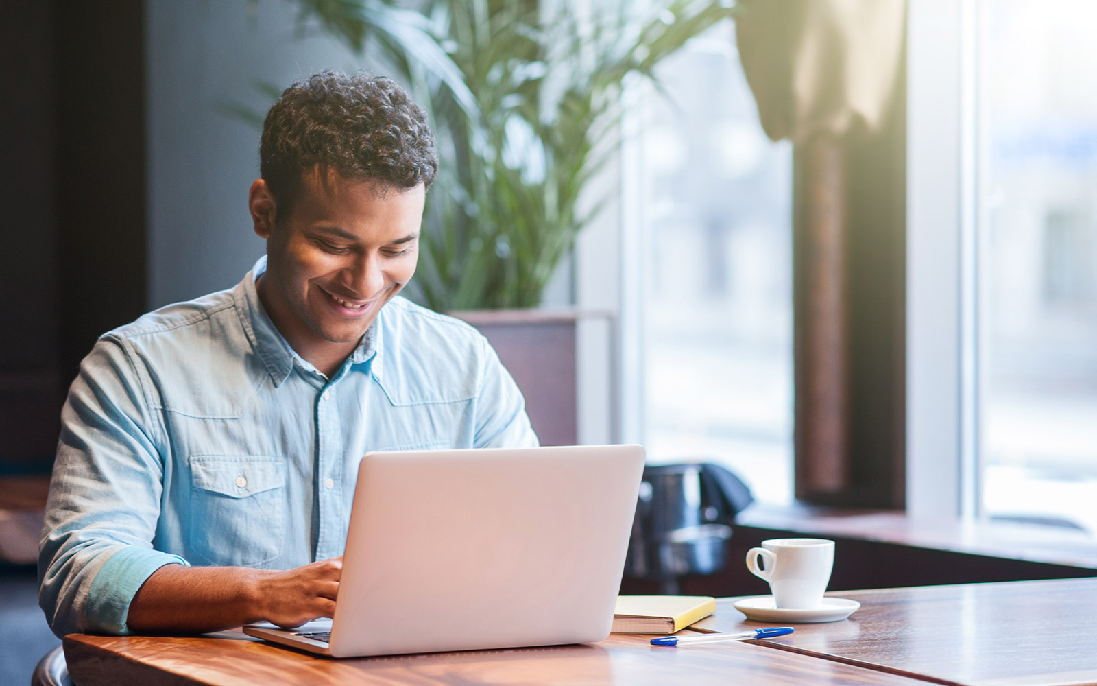 Man working on his laptop computer smiling