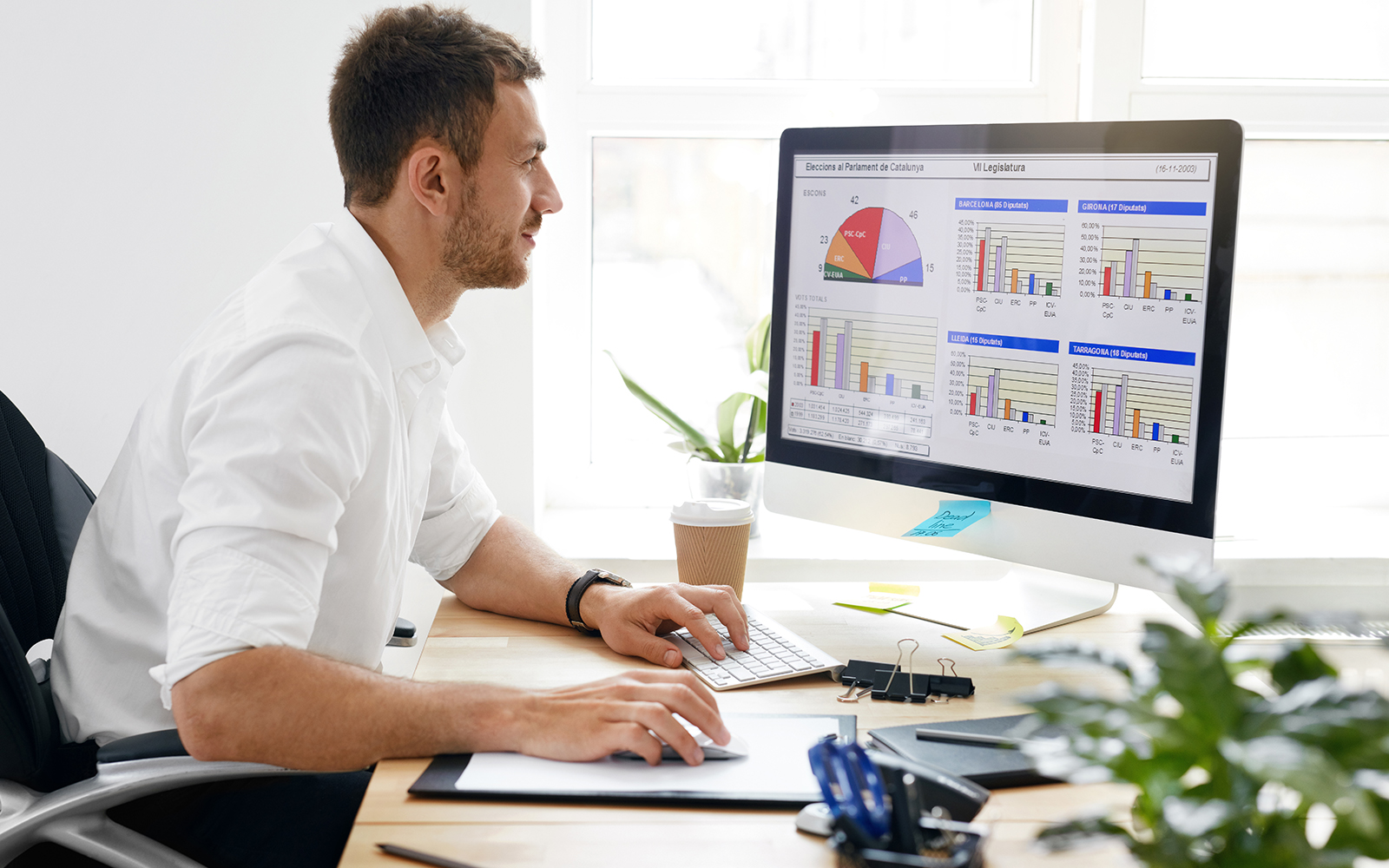 Man at desk analyzing data on computer