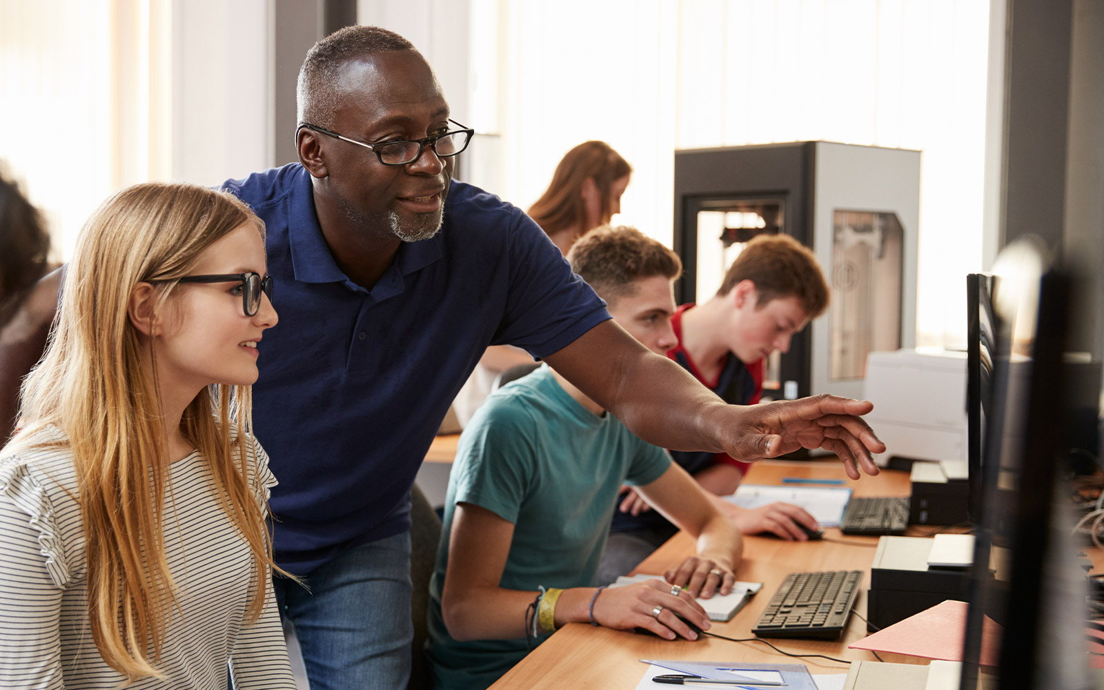 Teacher showing student something on the computer