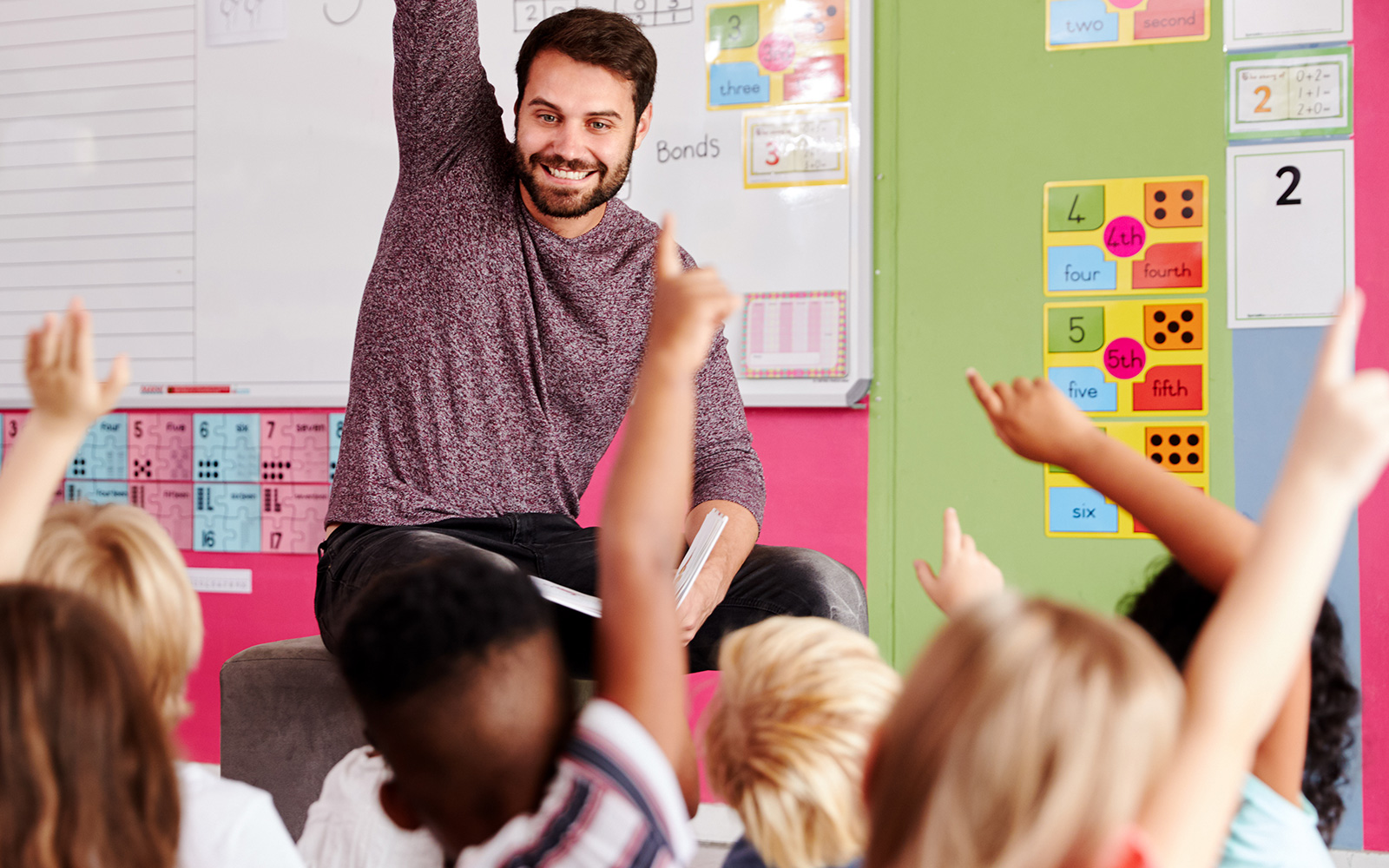Teacher raising his hand in front of class
