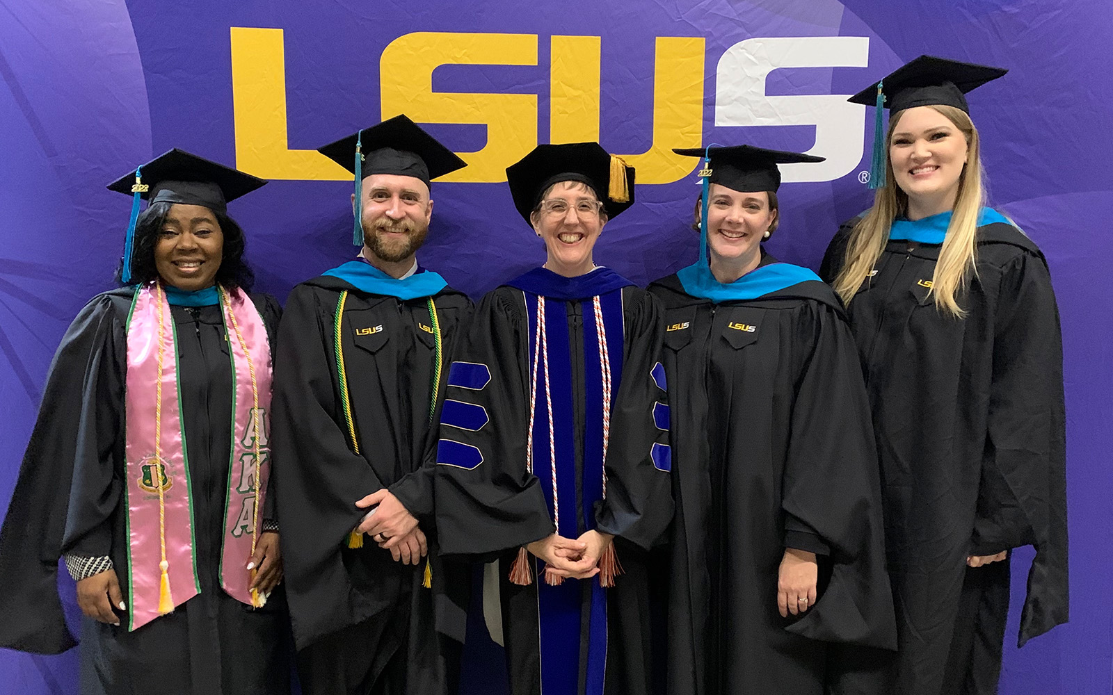 students and professor at photo booth at LSUS commencement