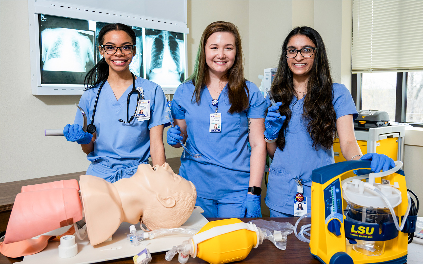 three female students in blue medical scrubs