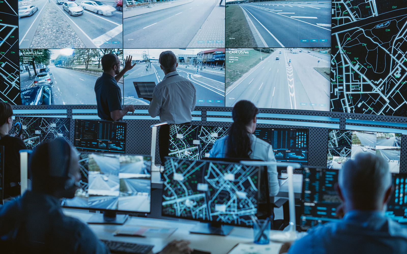 A control room with people monitoring surveillance screens.