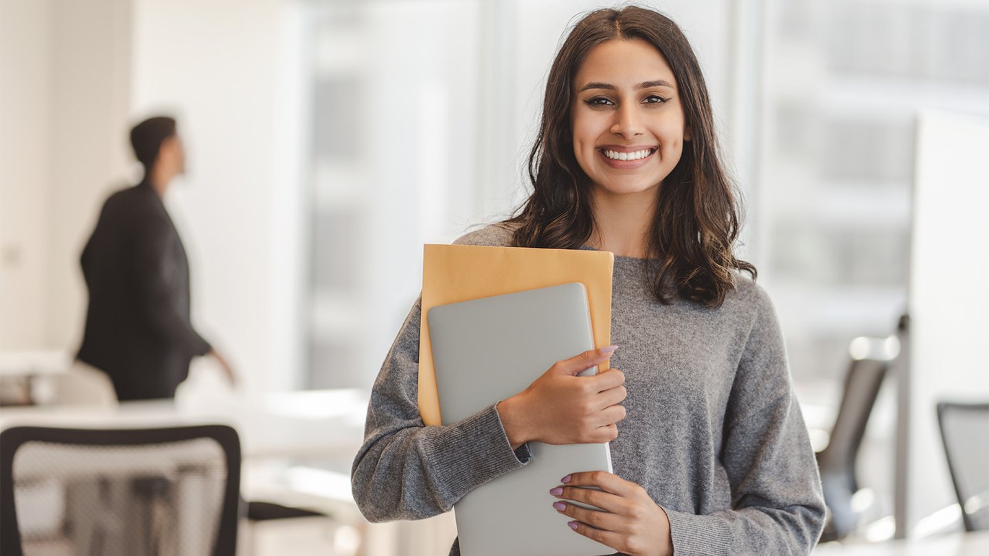 Woman holding books smiling