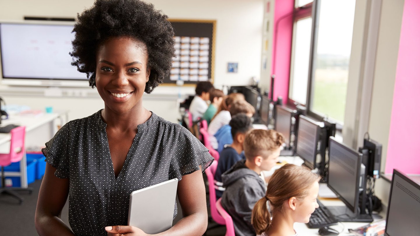Teacher in computer class with kids