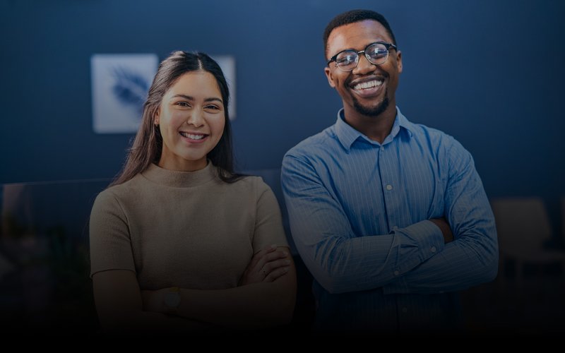 Portrait of two businesspeople standing with their arms crossed in an office