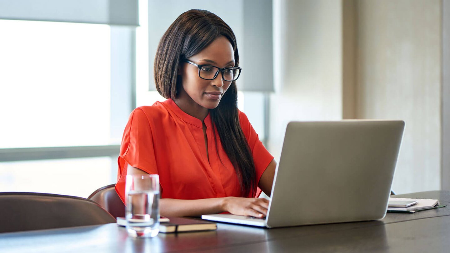 professional woman typing on laptop in office