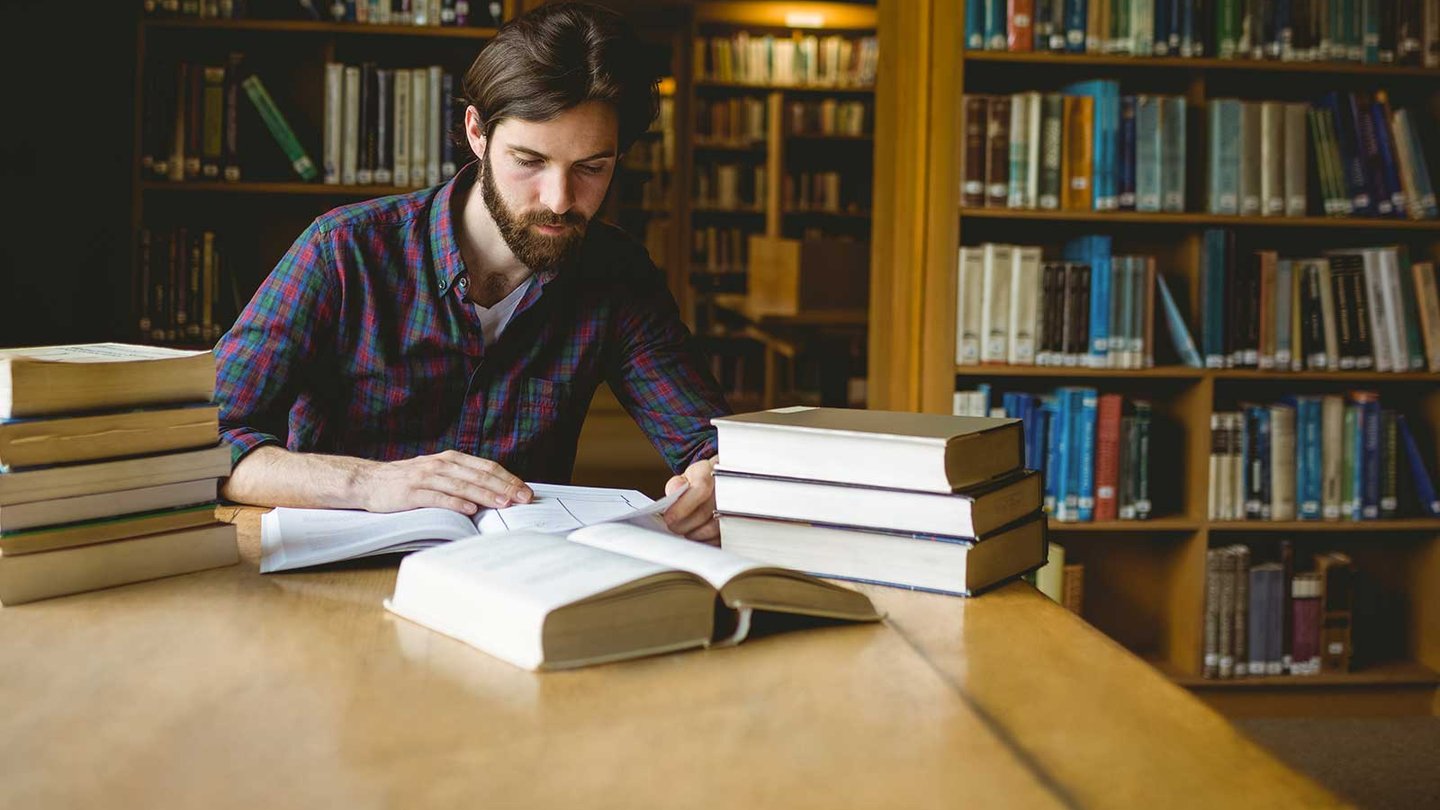 Religious studies student reading in library