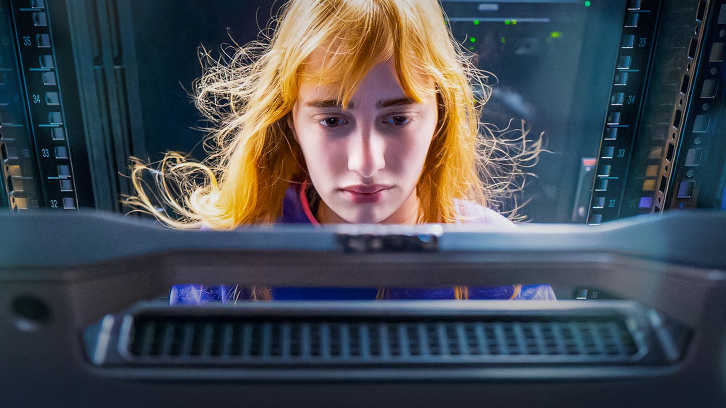 Young woman looking at a computer screen in a server room