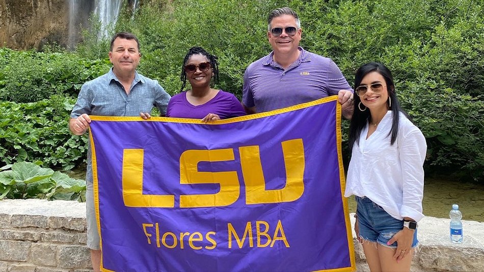 LSU Online MBA faculty with MBA flag while abroad