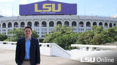 Man smiling in front LSU Tiger Stadium