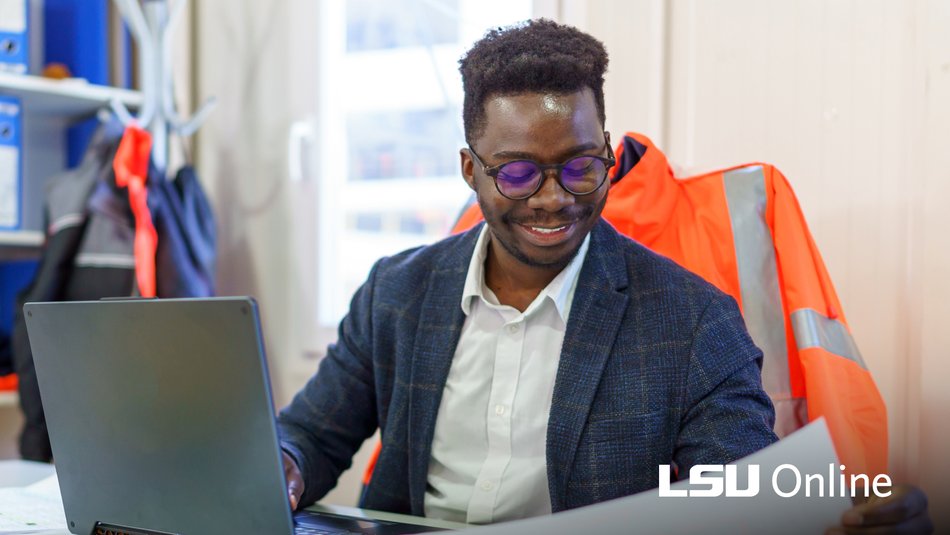 Construction engineer sitting in an onsite office reviewing plans