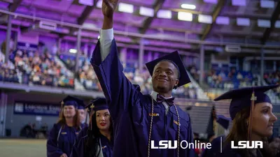 LSUA graduate smiling and waving.