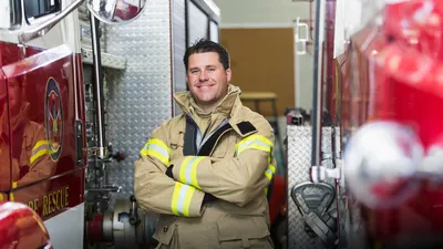 Fireman standing with arms crossed smiling at camera