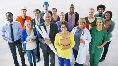 Different people in their professional wear smiling at the camera