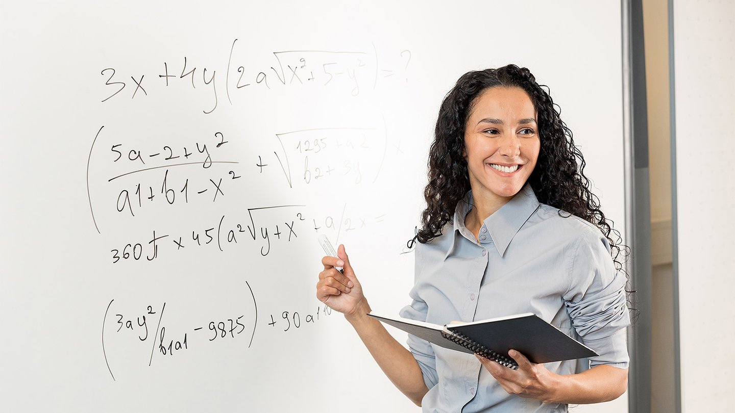 Math instructor writing on whiteboard