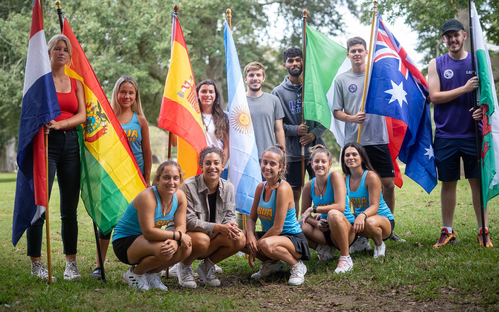Diverse group of students holding flags from different countries.