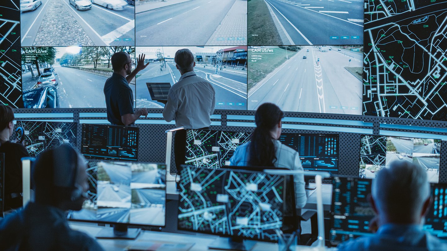 A control room with people monitoring surveillance screens.