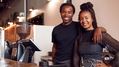 franchise owners posed in their coffee shop