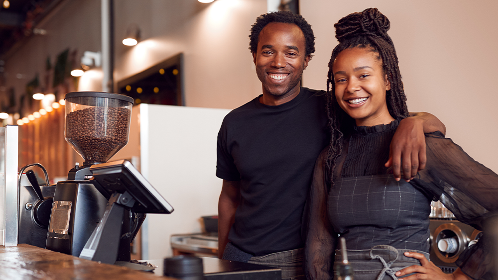 franchise owners posed in their coffee shop