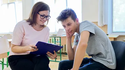Social worker woman showing documents to a teenager