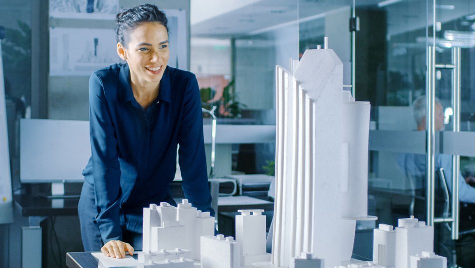 Construction manager looks at architectural model of project site.