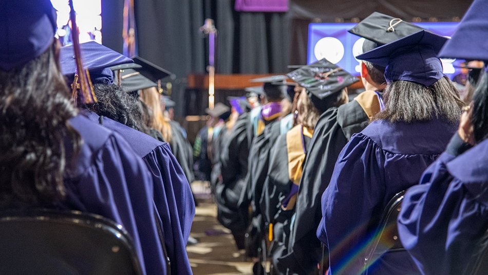 A close-up view from the back of LSU Online graduates sitting at their commencement ceremony.