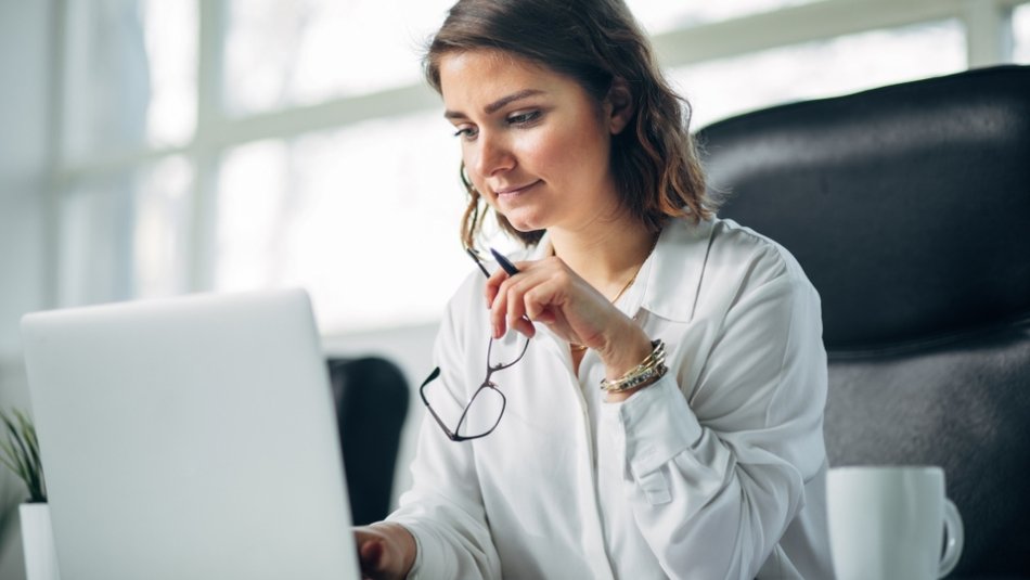 woman looking at a laptop- working on public administration