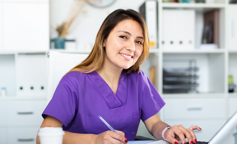 Nurse student studying at laptop.