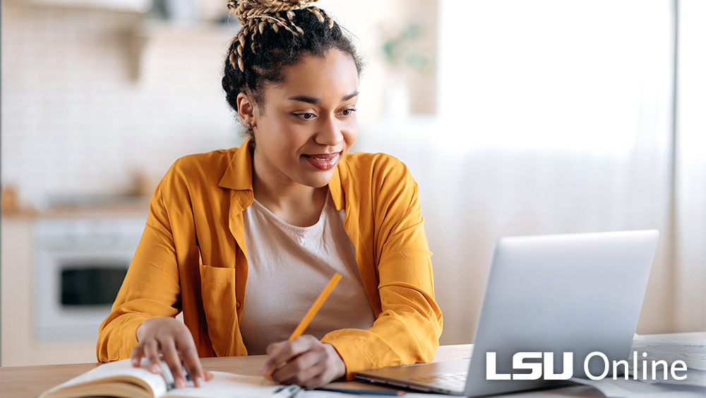 Woman smiling at her computer LSU Online