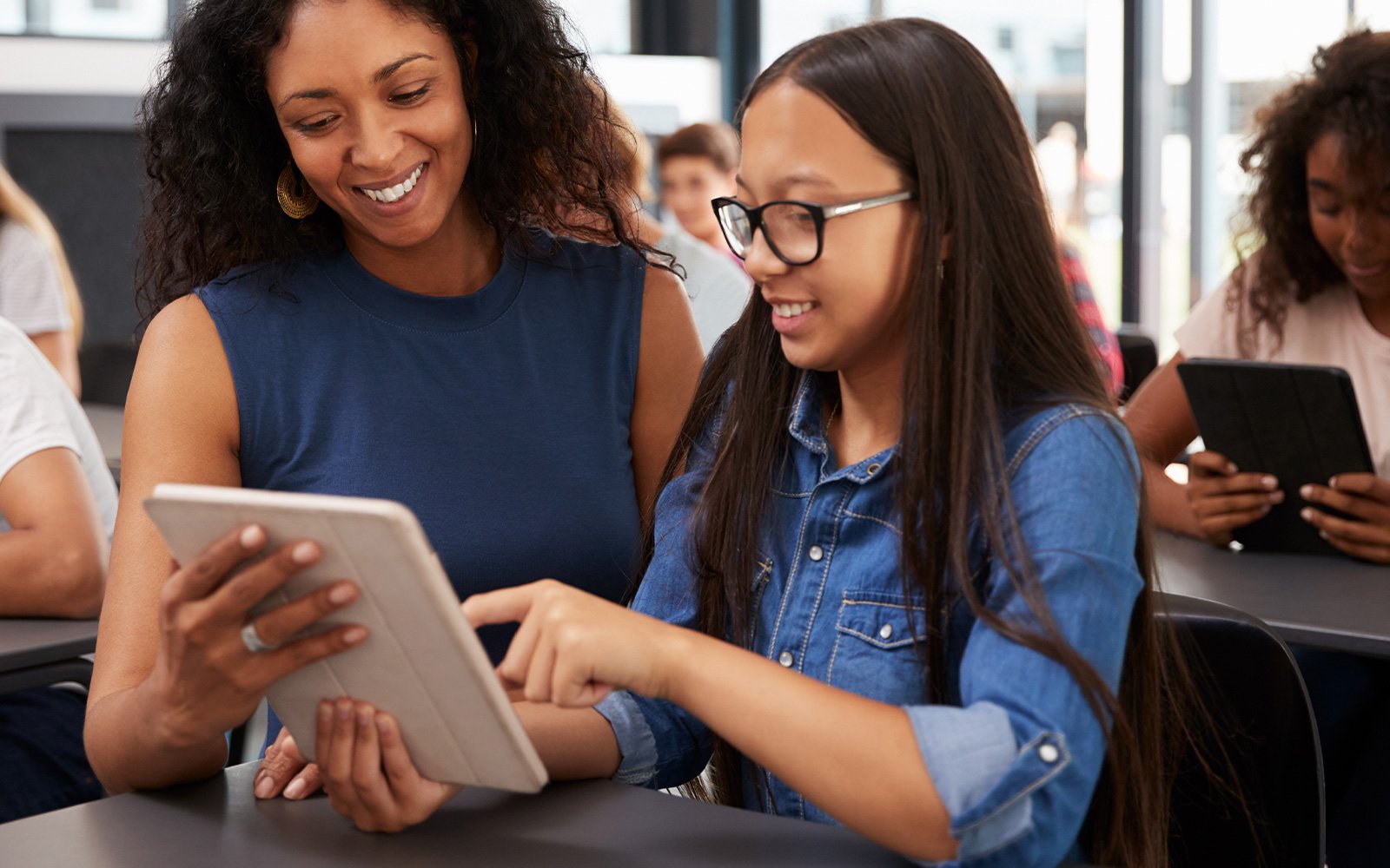 Teacher shows student something on a ipad