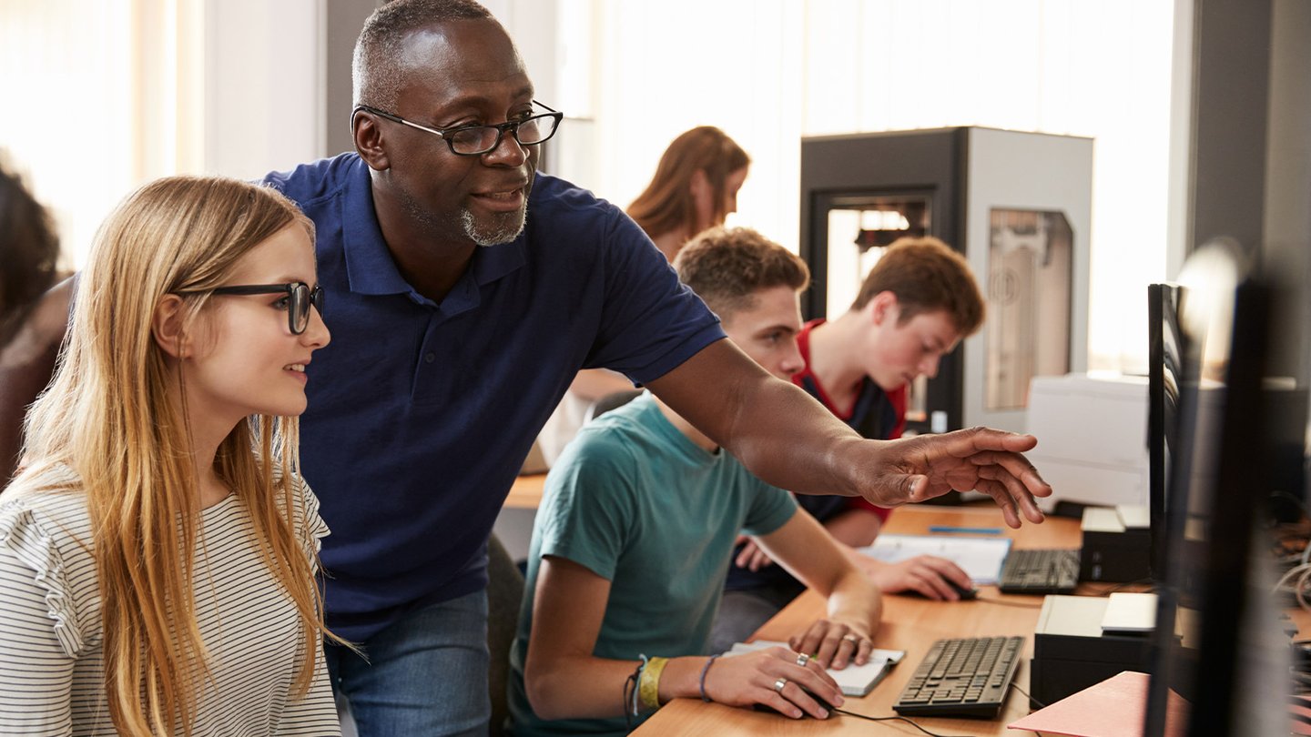 Teacher showing student something on the computer