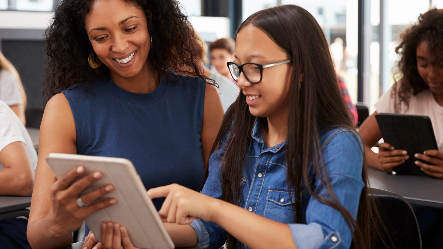 Teacher shows student something on a ipad