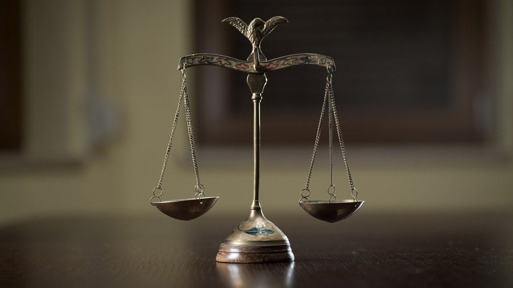 A close-up image of scales in a court room