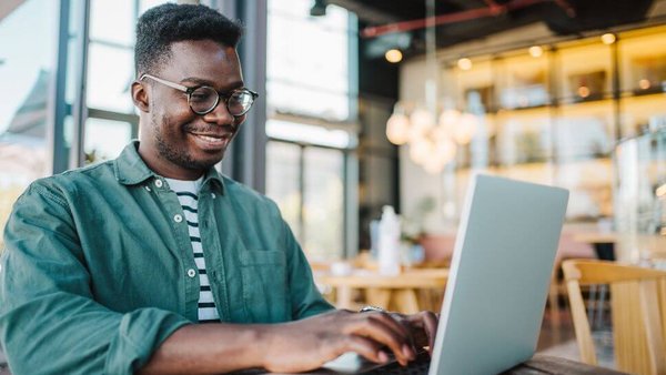 man on laptop at cafe