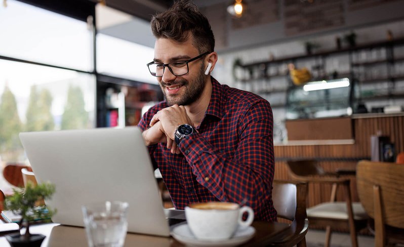 Online student using laptop in coffee shop
