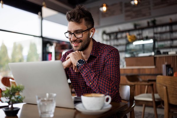 Online student using laptop in coffee shop