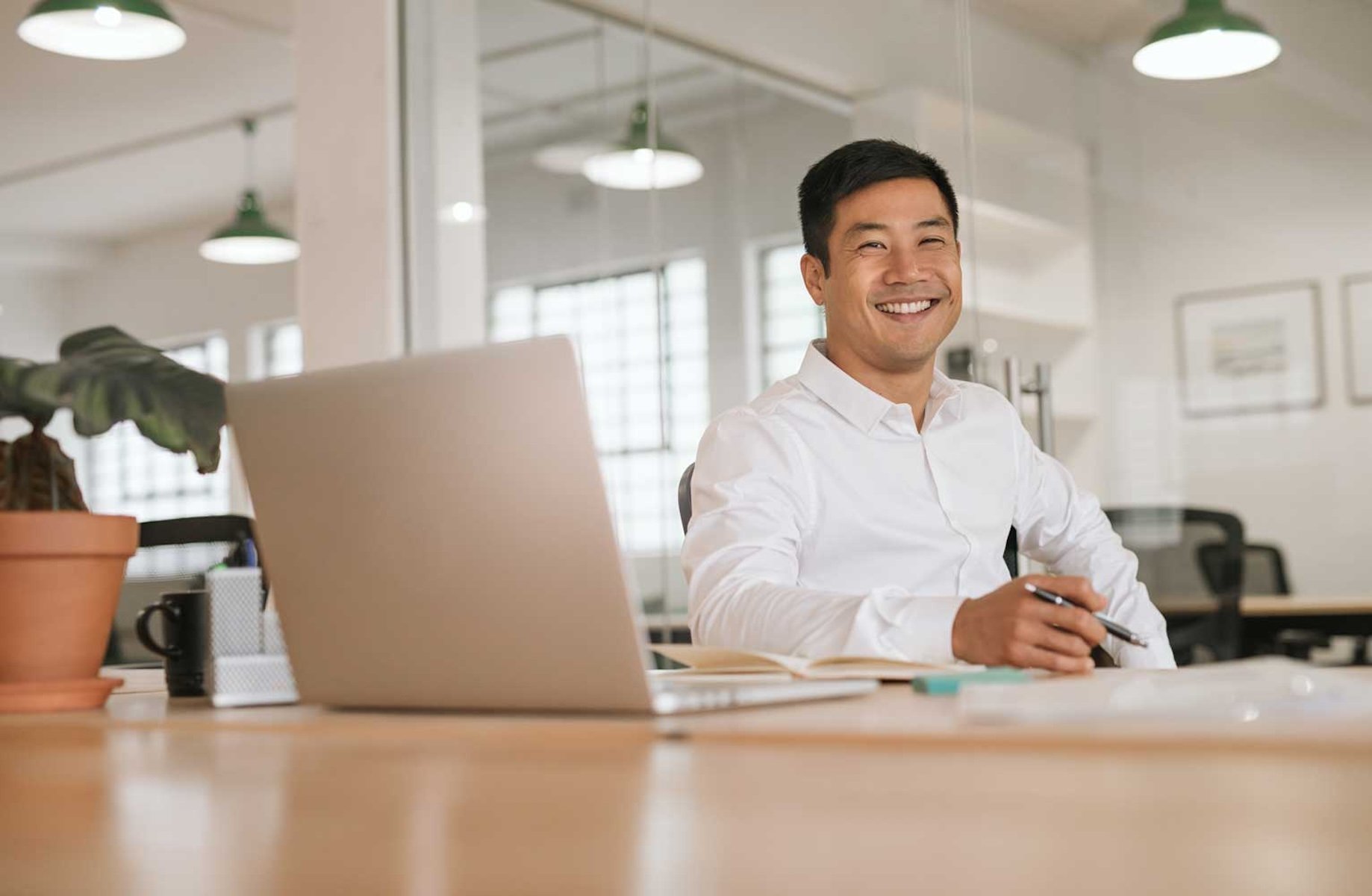 Professional man sitting at desk with pen in hand