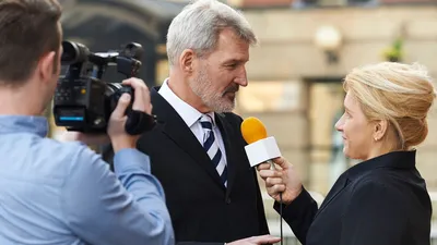 Political journalist interviews official on camera.