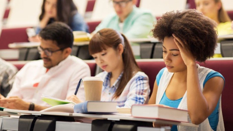A variety of undergraduates attend a lecture in a large classroom.