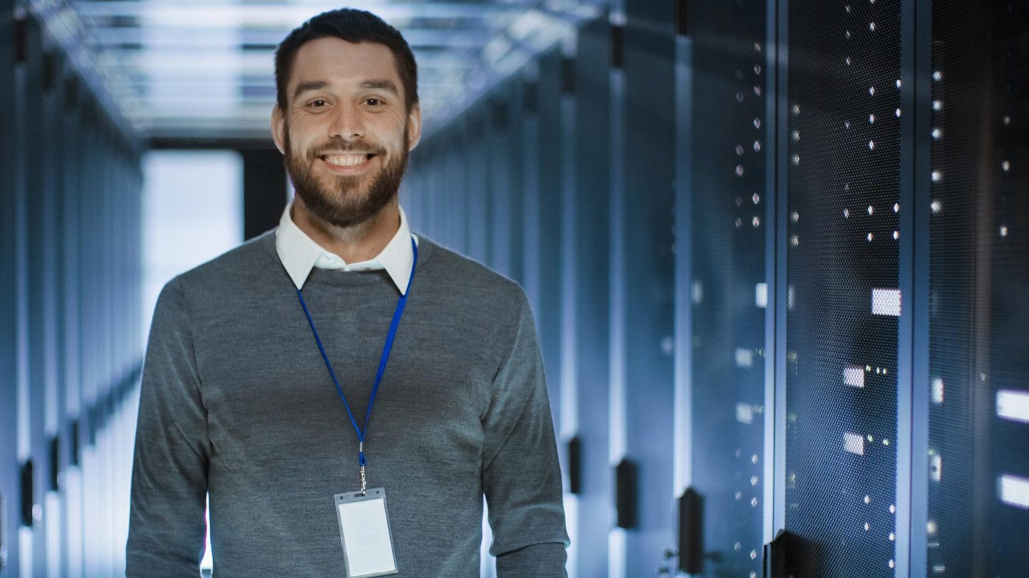 Professional man in tech standing in front of servers
