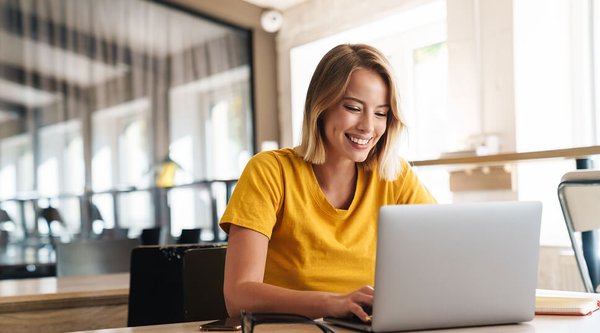 Woman using laptop and smiling