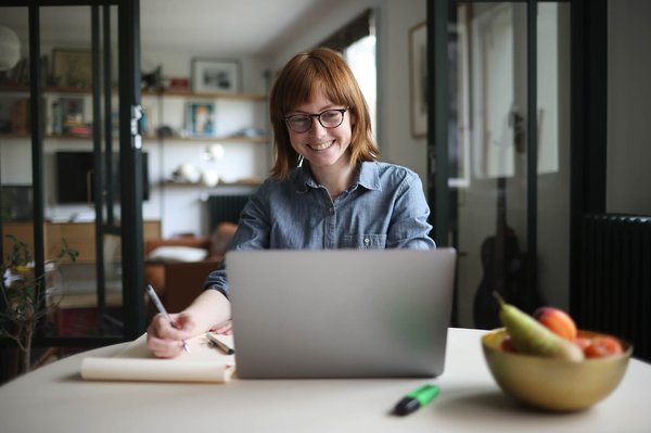 Woman on laptop and taking notes