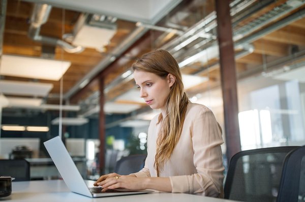Woman taking notes on laptop